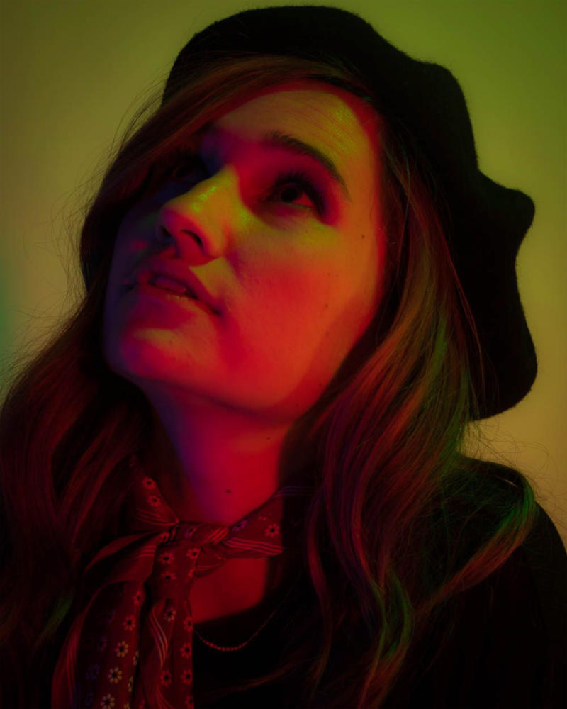Portrait of a woman in a beret in green lighting.
